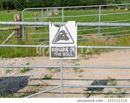 Beware of the bull sign on metal gate in rural West Cork farmland, Ireland on a sunny day. 131112114