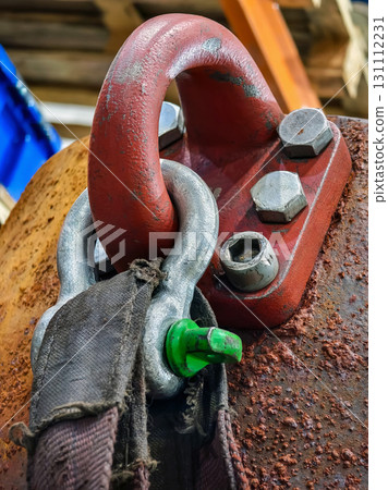 Details of a heavy-duty hook and rigging equipment in a construction site during daylight hours 131112231
