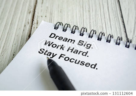 Dream Big And Think Limitless text written on a spiral notepad with inspirational handwriting in black pen. Dream Big And Think Limitless text written on a spiral notepad with inspirational handwriting in black pen. 131112604