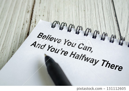 Believe you can, and you are halfway there text written on a spiral notepad with motivational handwriting in black pen. Believe you can, and you are halfway there text written on a spiral notepad with motivational handwriting in black pen. 131112605