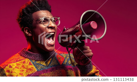 Young Student with Glasses Shouting in Joyful Expression with Megaphone 131113438