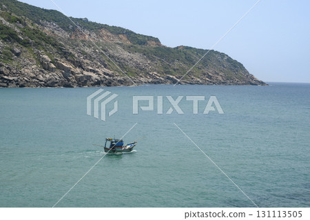 Fishing boat in a mountain-encircled bay of the South China Sea in Vietnam 131113505