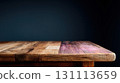 Wooden Table Against a Dark Wall in a Dimly Lit Room 131113659