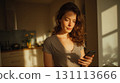 Young Adult Woman Shopping on Smartphone at Home in Natural Light 131113666