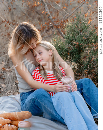 Mother sitting with her daughter outdoor with sunshine. Mother sitting with her daughter outdoor with sunshine. 131113694