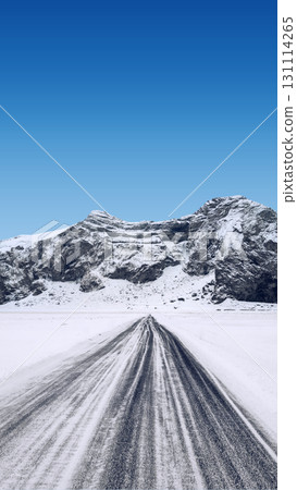 View of a long road stretches towards the snow-covered mountain under a bright blue sky on a winter day. Beautiful landscape for a natural or winter background or wallpaper View of a long road stretches towards the snow-covered mountain under a bright blue sky on a winter day. Beautiful landscape for a natural or winter background or wallpaper 131114265