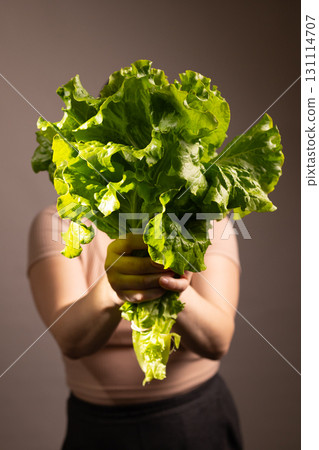Person Holding Fresh Lettuce in Front of Face Person Holding Fresh Lettuce in Front of Face 131114707
