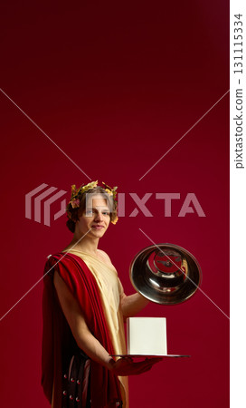 Young man in toga smiling with silver tray and blank box for creative presentation Young man in toga smiling with silver tray and blank box for creative presentation 131115334