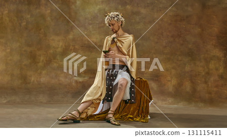 Man in toga sitting with smartphone and concentrated look Man in toga sitting with smartphone and concentrated look 131115411