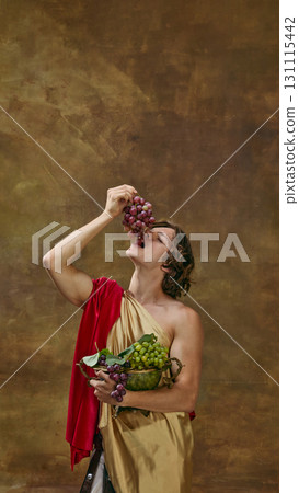 Man in toga enjoying grapes with playful expression Man in toga enjoying grapes with playful expression 131115442