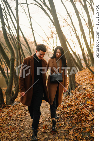 Young couple in love walking in the park on a autumn day. Enjoying time together. Young couple in love walking in the park on a autumn day. Enjoying time together. 131115750