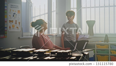 Talented Boy Singing Song During Vocal Lesson. Music Teacher Playing Piano, Supporting Young Student Talented Boy Singing Song During Vocal Lesson. Music Teacher Playing Piano, Supporting Young Student 131115780