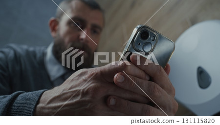 Businessman Using Smartphone, Sitting on the Toilet, Scrolling Media Content Businessman Using Smartphone, Sitting on the Toilet, Scrolling Media Content 131115820