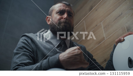 Man Sitting on the Toilet and Suffering from Diarrhea and Stomach Ache in Restroom 131115959