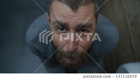 Top View on Man with Tense Facial Expression Sitting on Toilet, Suffering from Diarrhea 131116039