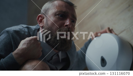 Businessman with Tense Facial Expression Suffering from Diarrhea and Indigestion, Sitting on the Toilet 131116070