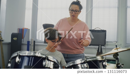 Primary School Boy Practicing Sense of Rhythm, Playing Drums in Music Class 131116073