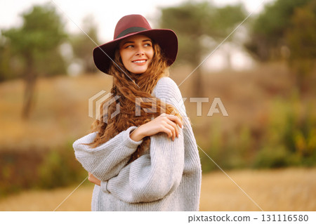 Stylish woman in hat enjoying autumn weather in the park. Fashion, style concept. 131116580