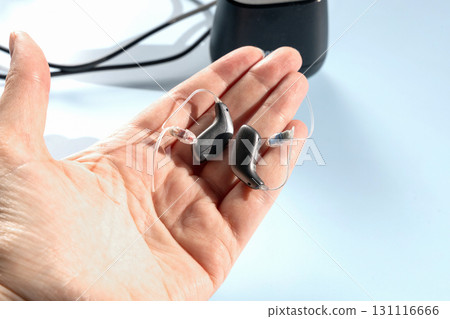 Female hand holding modern hearing aid 131116666