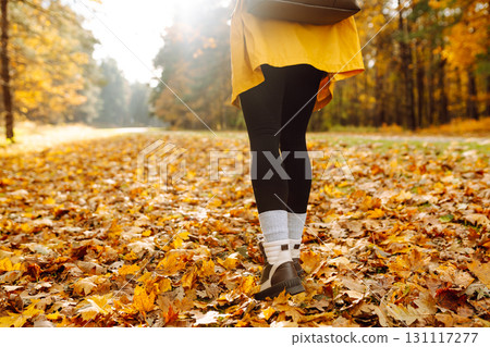 Female legs in boots walking through fallen trees in autumn park. Nature, travel concept. 131117277