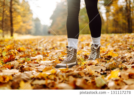 Female legs in boots walking through fallen trees in autumn park. Nature, travel concept. 131117278