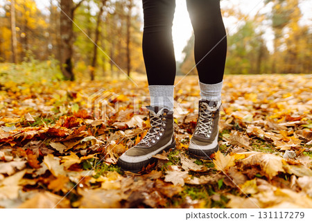 Female legs in boots walking through fallen trees in autumn park. Nature, travel concept. 131117279