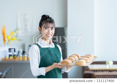 A cafe clerk recommending bread A cafe clerk recommending bread 131117400