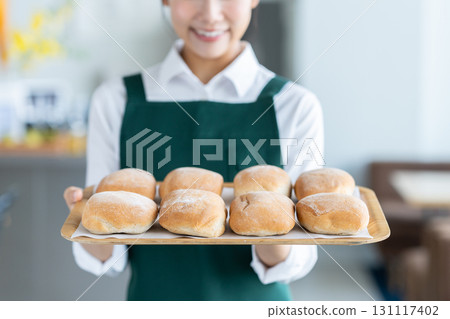 A cafe clerk recommending bread 131117402