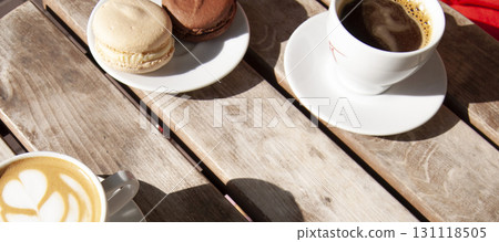 Coffee and macaroons on the wooden table. Coffee shop frame with copy space. 131118505