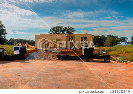 Build new house takes shape with wooden frames under works day in developing neighborhood. Build new house takes shape with wooden frames under works day in developing neighborhood. 131120349