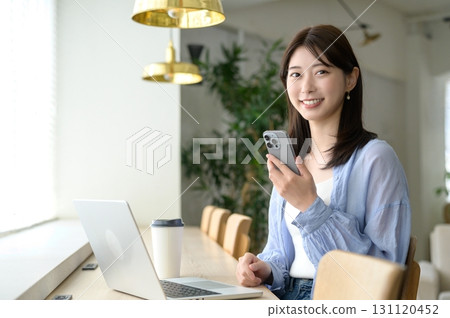 Woman looking at camera by the window in a cafe 131120452
