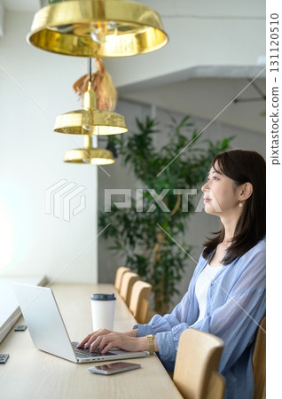 A woman working by the window in a cafe A woman working by the window in a cafe 131120510