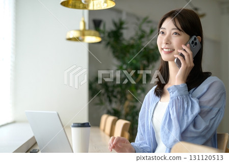 A woman working by the window in a cafe 131120513