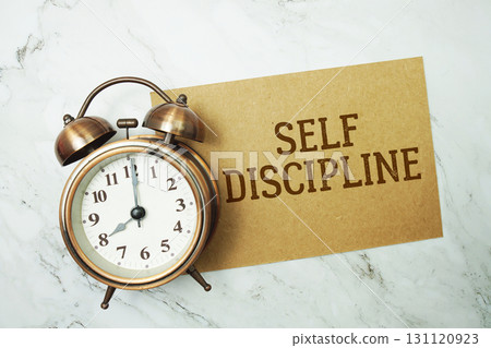 Self Discipline text written on paper card with alarm clock on marble background Self Discipline text written on paper card with alarm clock on marble background 131120923
