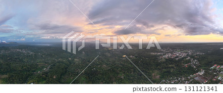 Sunset view over lush green landscape near small town Sunset view over lush green landscape near small town 131121341