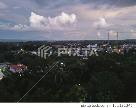 Sunset over quiet town surrounded by trees and mountains 131121345