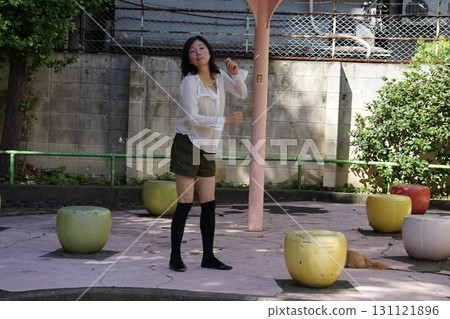 Tall woman sitting on a park bench 131121896
