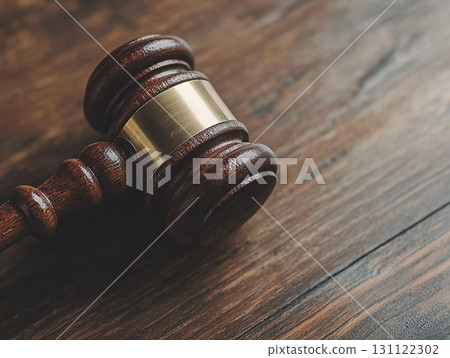 A wooden judge's gavel on a polished table, symbolizing law and justice. A wooden judge's gavel on a polished table, symbolizing law and justice. 131122302