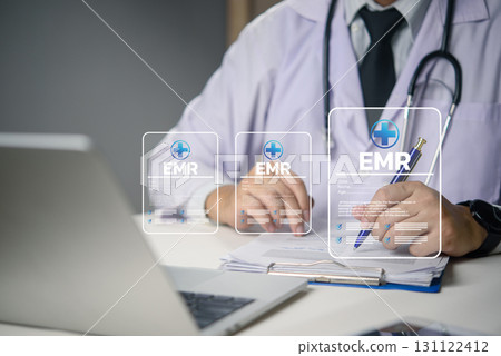 Doctor working on EMR system with digital medical data, healthcare technology, electronic records, and telemedicine concept for modern hospital management. 131122412