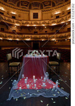 Romantic Red Table Setup in Historic Theatre: Candlelit Dinner, Floral Arrangement, Wedding Proposal, Dark Interior, Dramatic Lighting 131123162