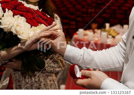 Romantic Proposal with Red Roses: Diamond Ring, Intimate Setting, Candles, Passionate Love, Engagement Celebration, Warm Lighting Romantic Proposal with Red Roses: Diamond Ring, Intimate Setting, Candles, Passionate Love, Engagement Celebration, Warm Lighting 131123167