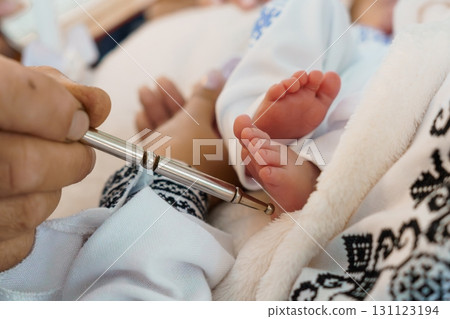 Newborn Heel Prick Test: Doctor's Hand Performing Screening on Baby's Foot with Steel Lancet, Light Blue and White Textile Background Newborn Heel Prick Test: Doctor's Hand Performing Screening on Baby's Foot with Steel Lancet, Light Blue and White Textile Background 131123194