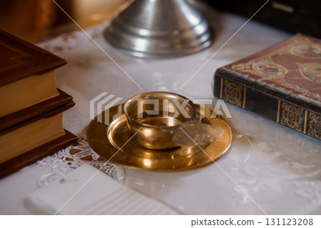 Sacred Still Life: Religious Ceremony Objects with Books, Candle Holders, and Chalice on Lace Tablecloth, Golden Tones and Vintage Aesthetic 131123208