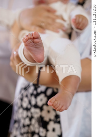 Tender Mother Holding Newborn Baby Feet Close-Up, White Clothing, Black Floral Pattern, Soft Focus, Parental Love, Delicate Skin, Warm Tone Tender Mother Holding Newborn Baby Feet Close-Up, White Clothing, Black Floral Pattern, Soft Focus, Parental Love, Delicate Skin, Warm Tone 131123216