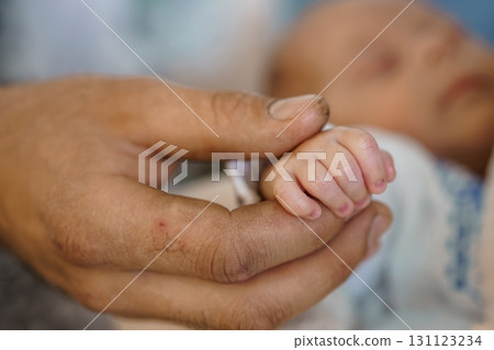 Newborn Baby Hand Holding Father's Finger. Intimate Connection, Tender Love, Soft Focus, Warm Colors, Parent-Child Relationship, First Touch. 131123234