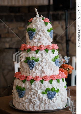 Exquisite Four-Tier Wedding Cake with Rosettes and Floral Accents, White Frosting, Pink Roses, Blue Decorations, Celebration, Elegant Dessert Exquisite Four-Tier Wedding Cake with Rosettes and Floral Accents, White Frosting, Pink Roses, Blue Decorations, Celebration, Elegant Dessert 131123268