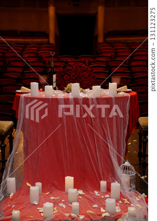 Romantic Valentine's Day Table Setting in Theater: Red Roses, Wine, Candles, Dramatic Lighting, Intimate Event. 131123275