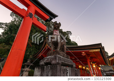 Sunrise at Fushimi Inari Taisha Kyoto with guardian fox statue torii gate and shrine architecture 131123300