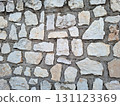 A close-up view of a wall finished with natural stone, highlighting the varied shapes and textures of the stones. This scene captures the preparation stage before the final plastering. 131123369