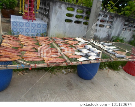 A Display of Dried Fish on a Netting Table Supported by Blue Barrels in an Outdoor Market A Display of Dried Fish on a Netting Table Supported by Blue Barrels in an Outdoor Market 131123674